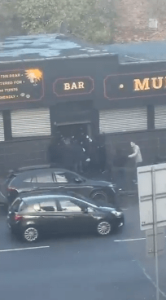 Shock moment Scottish football ultras clash on busy Glasgow street as fans chased by rival hooligans into pub doorway